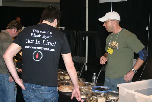 Visitors looking over rows of labelled deli cups at a breeder table