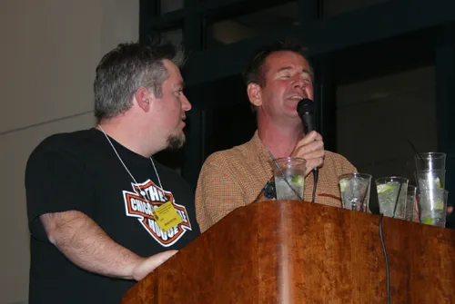 Two hosts at the podium working the Saturday-night benefit auction