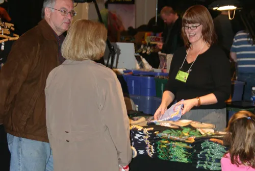 A family browsing a vendor table stocked with plush reptiles