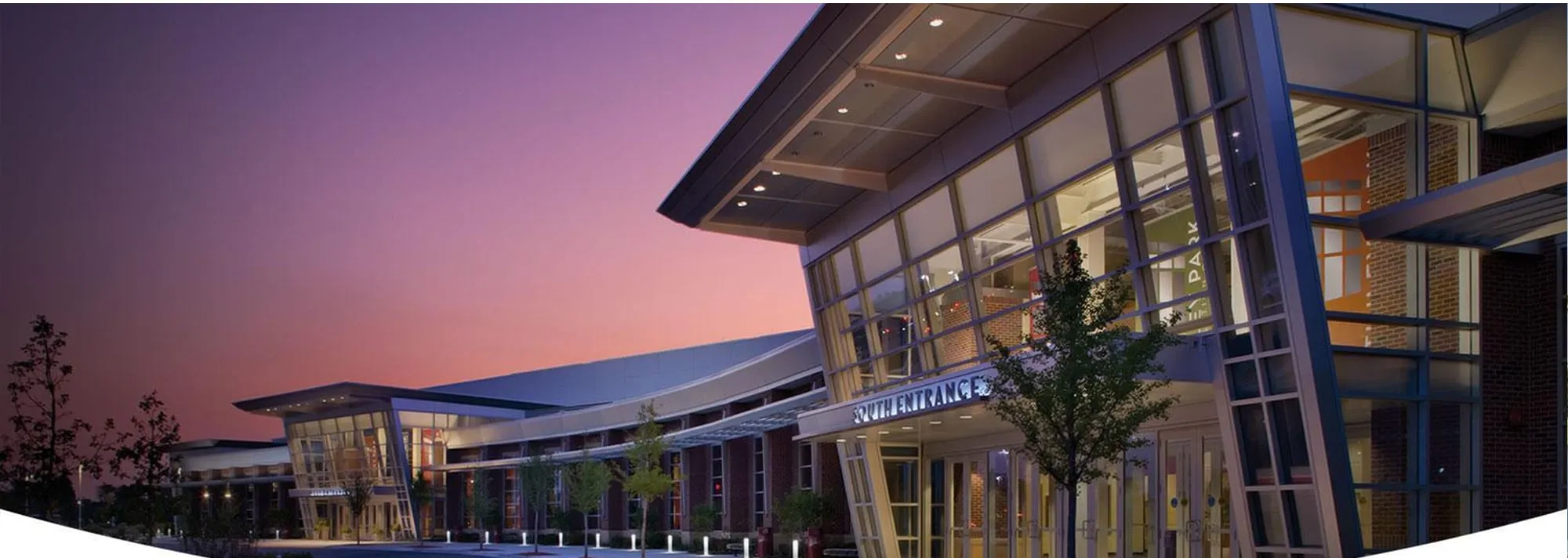 Tinley Park Convention Center's glass south entrance lit at dusk
